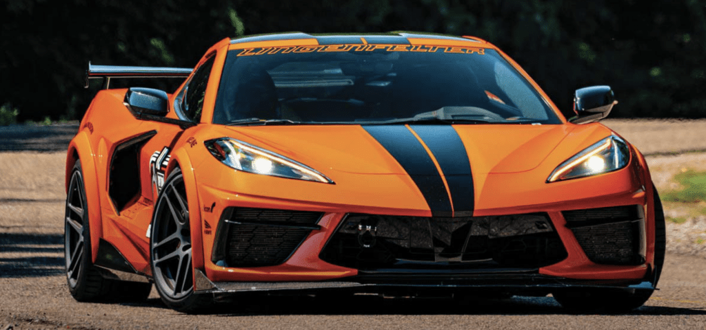 Sleek orange and black Corvette racing down the highway, embodying speed and performance.